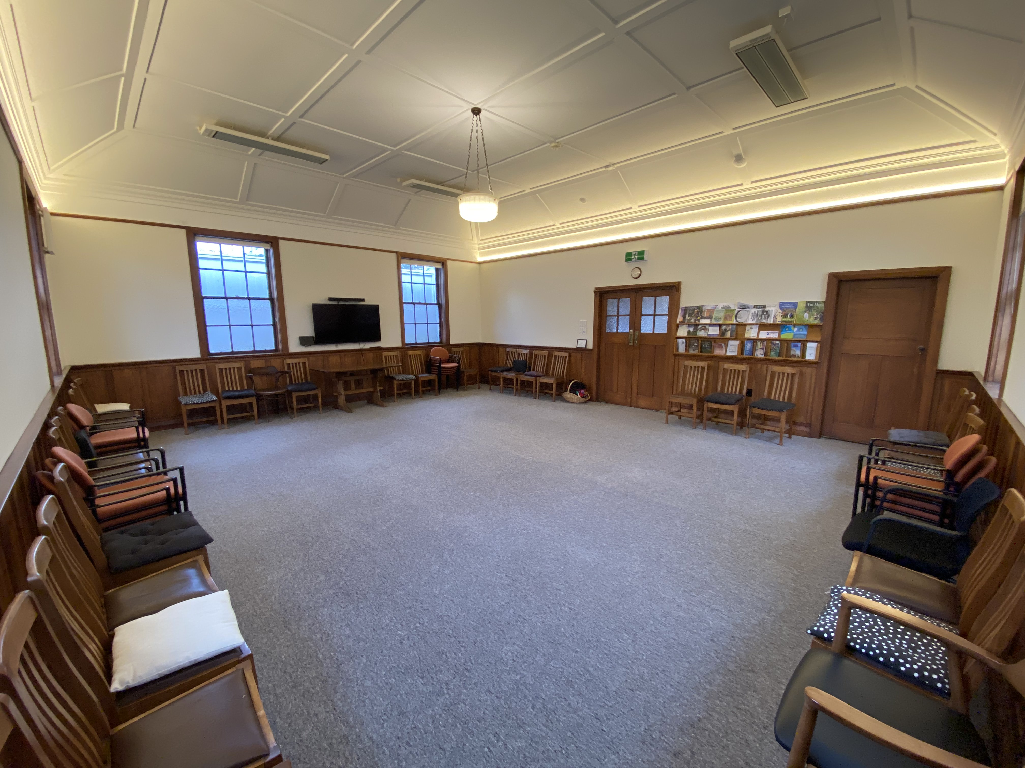 A large carpeted room with chairs along the walls