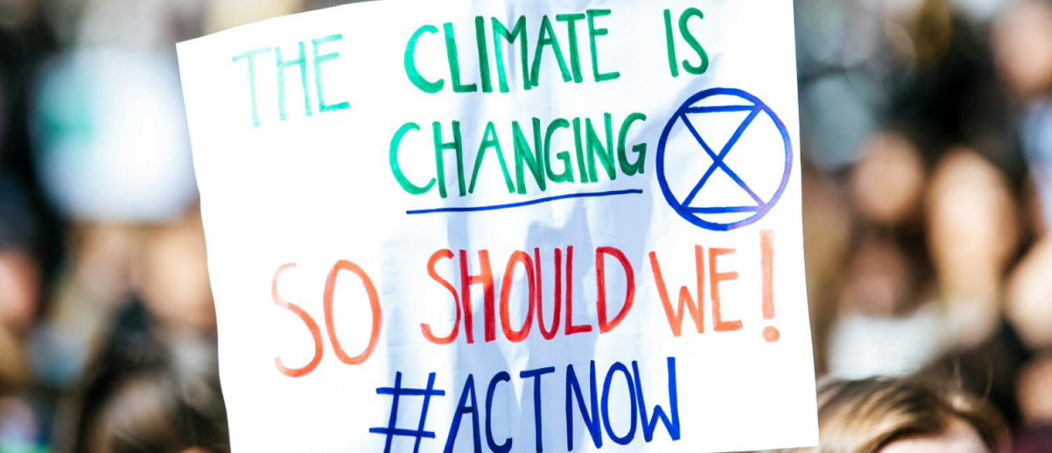 plackard with words the climate is changing so should we act now