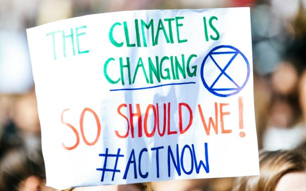 plackard with words the climate is changing so should we act now