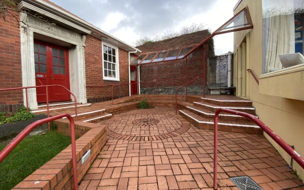 A brick courtyard between two buildings. The left building says "Friends House" over the door.